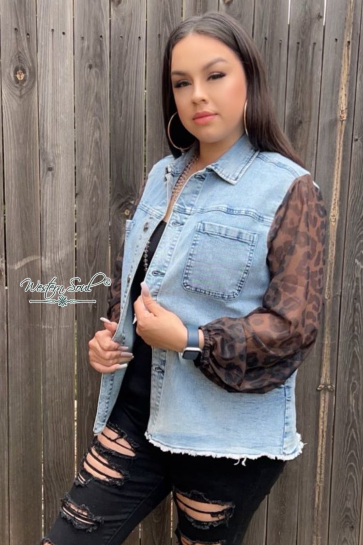 Model standing by wood fence wearing denim jacket by crazy train clothing