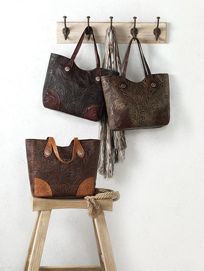 American West Concealed carry handbags group image, 2 bags hanging on hooks and 3rd sitting on stool 