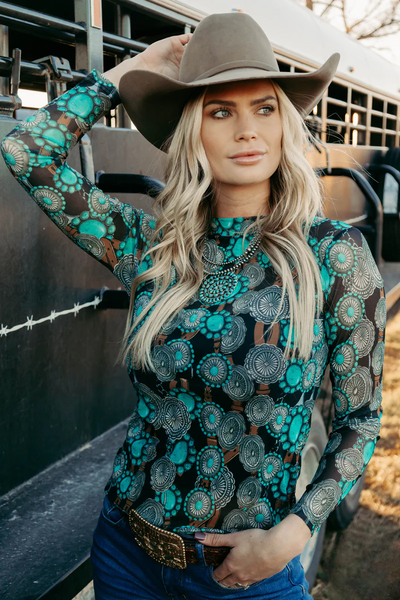 model wearing concho queen mesh top standing by a stock trailer