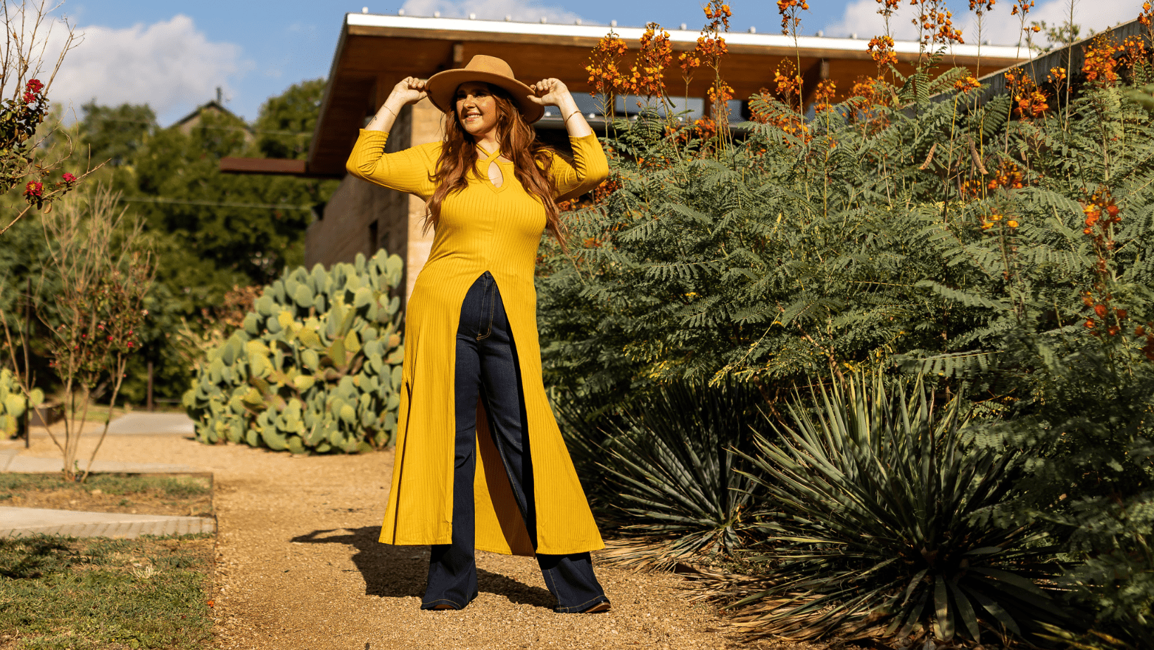 curvy model wearing plus size long mustard tunic and dark wash flare jeans