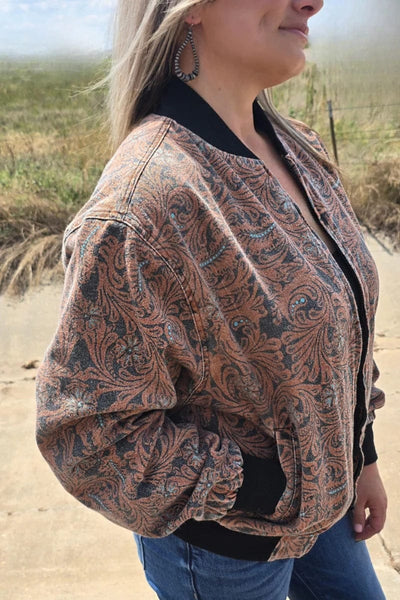 Model wearing a tooled pattern jacket outdoors with a blurred background